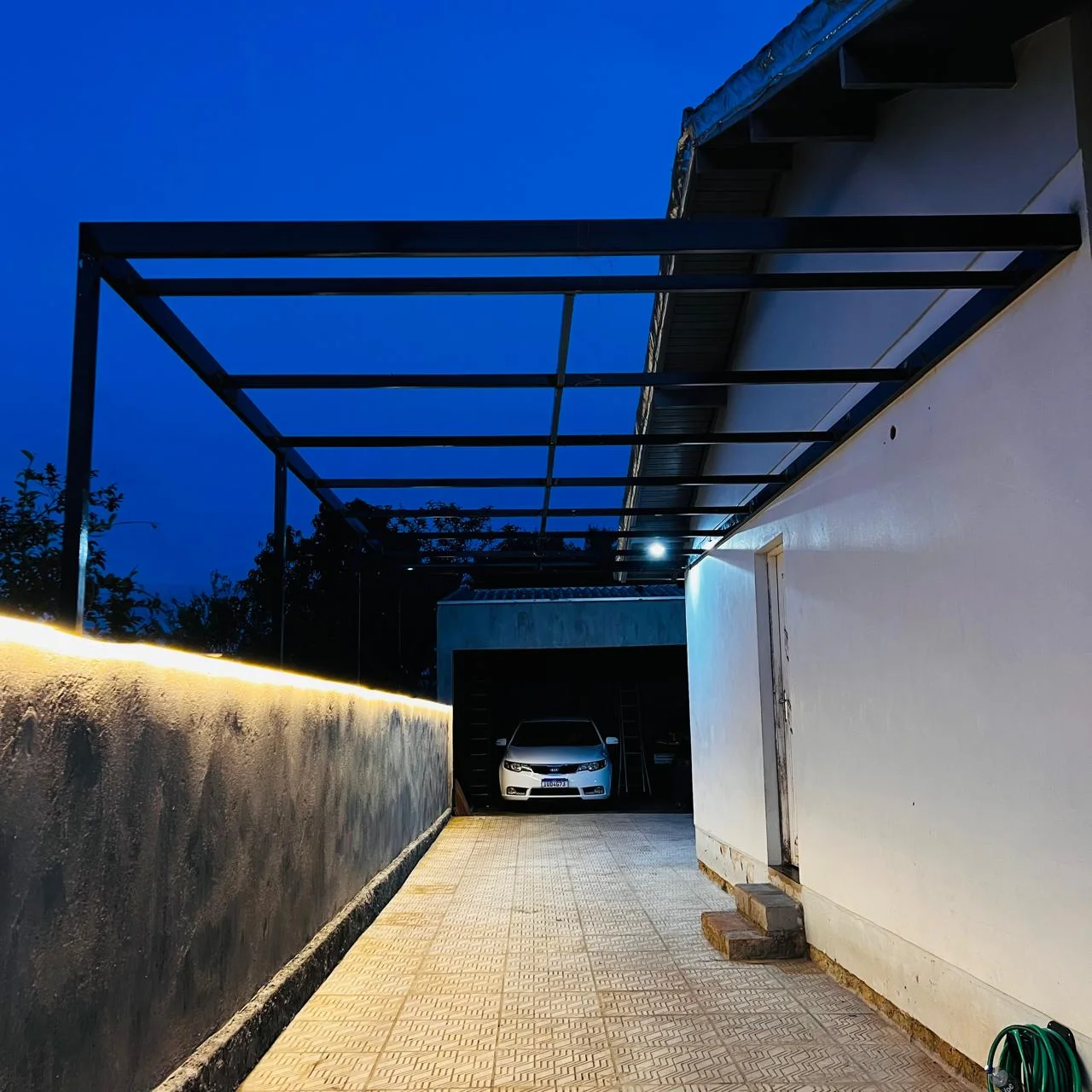 Pergolado metálico da Serralheria LC com iluminação em corredor residencial